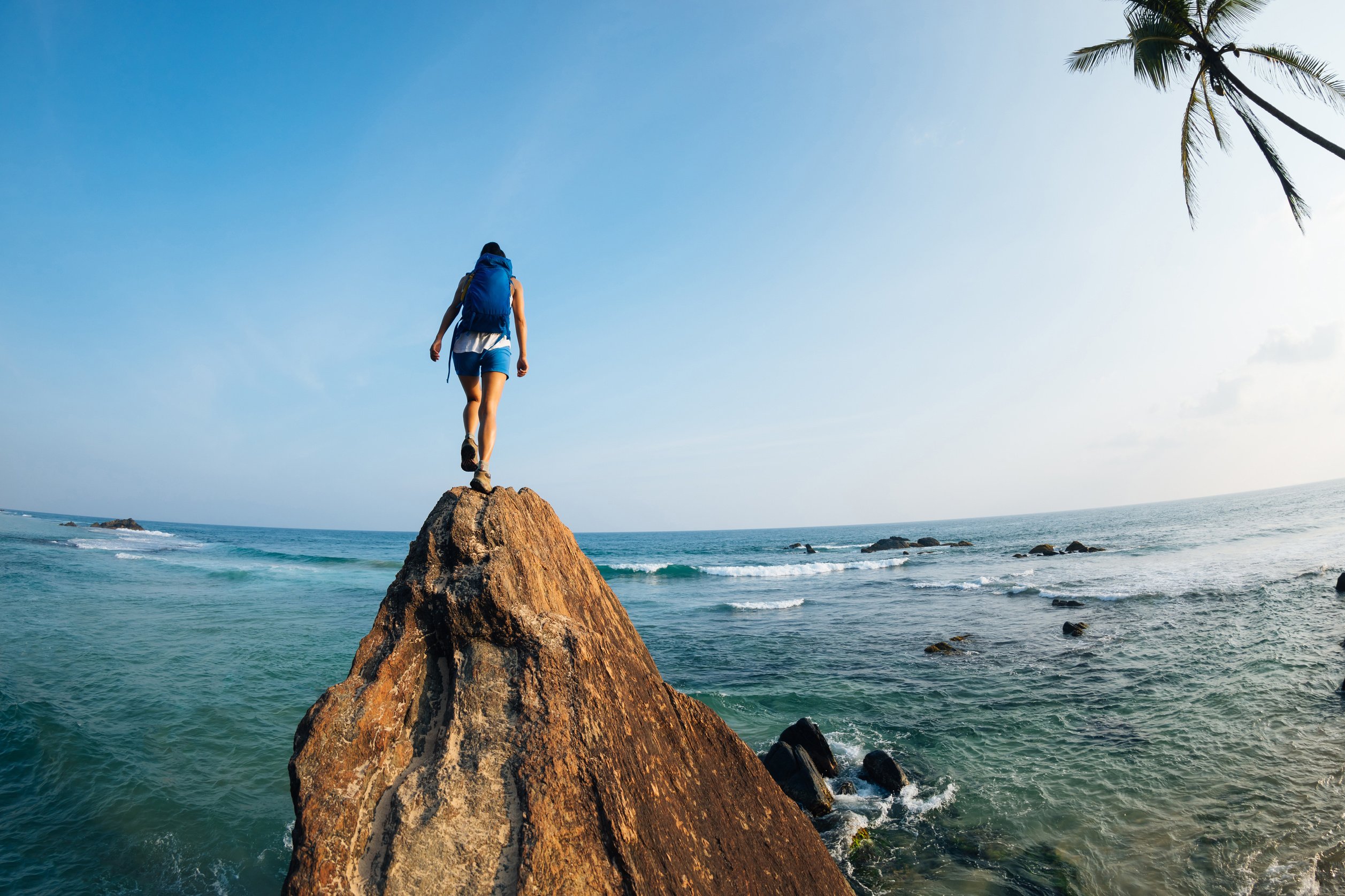 Brave woman walking to the cliff edge at seaside